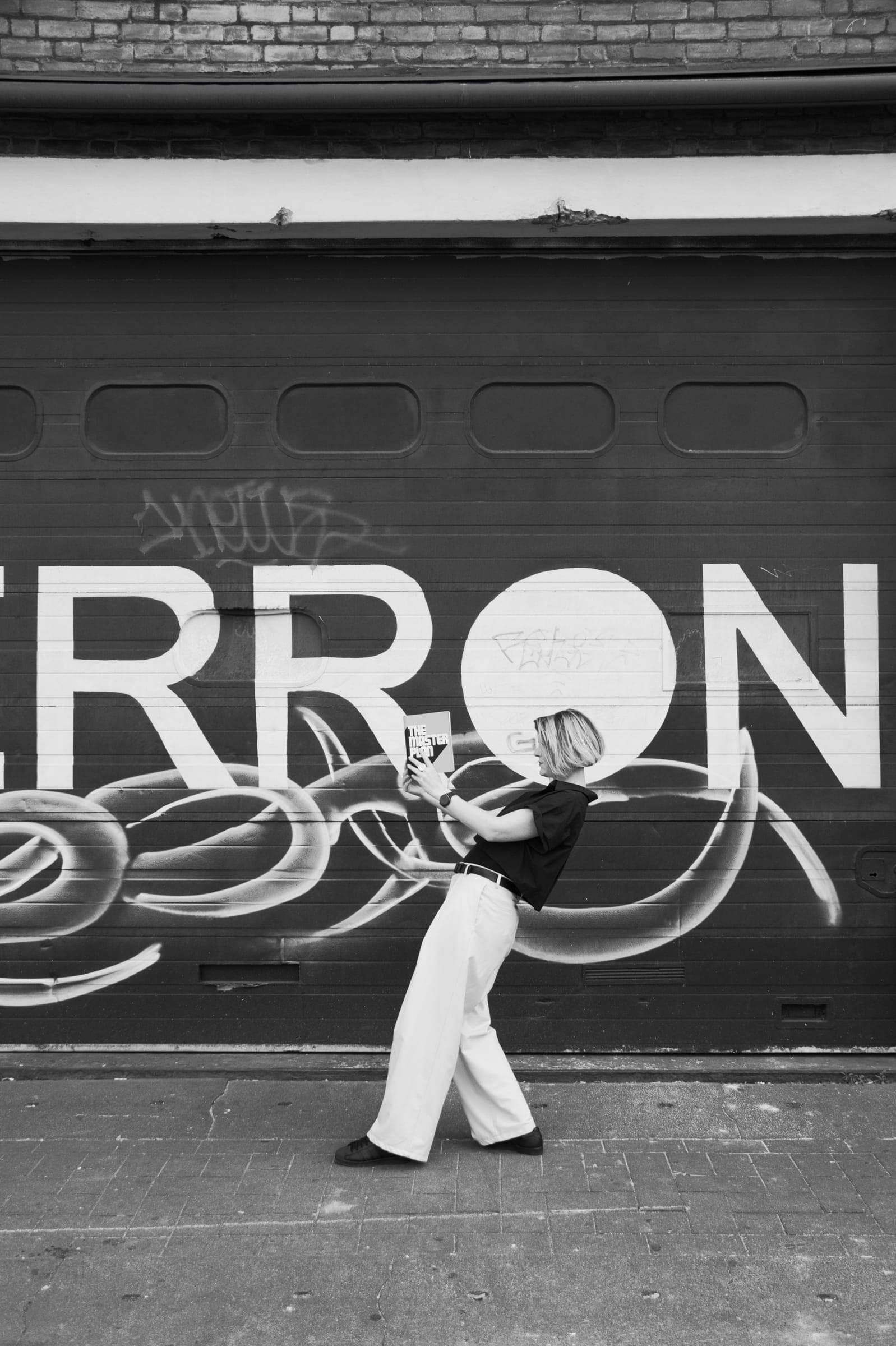 Els leest een boek voor een graffitimuur