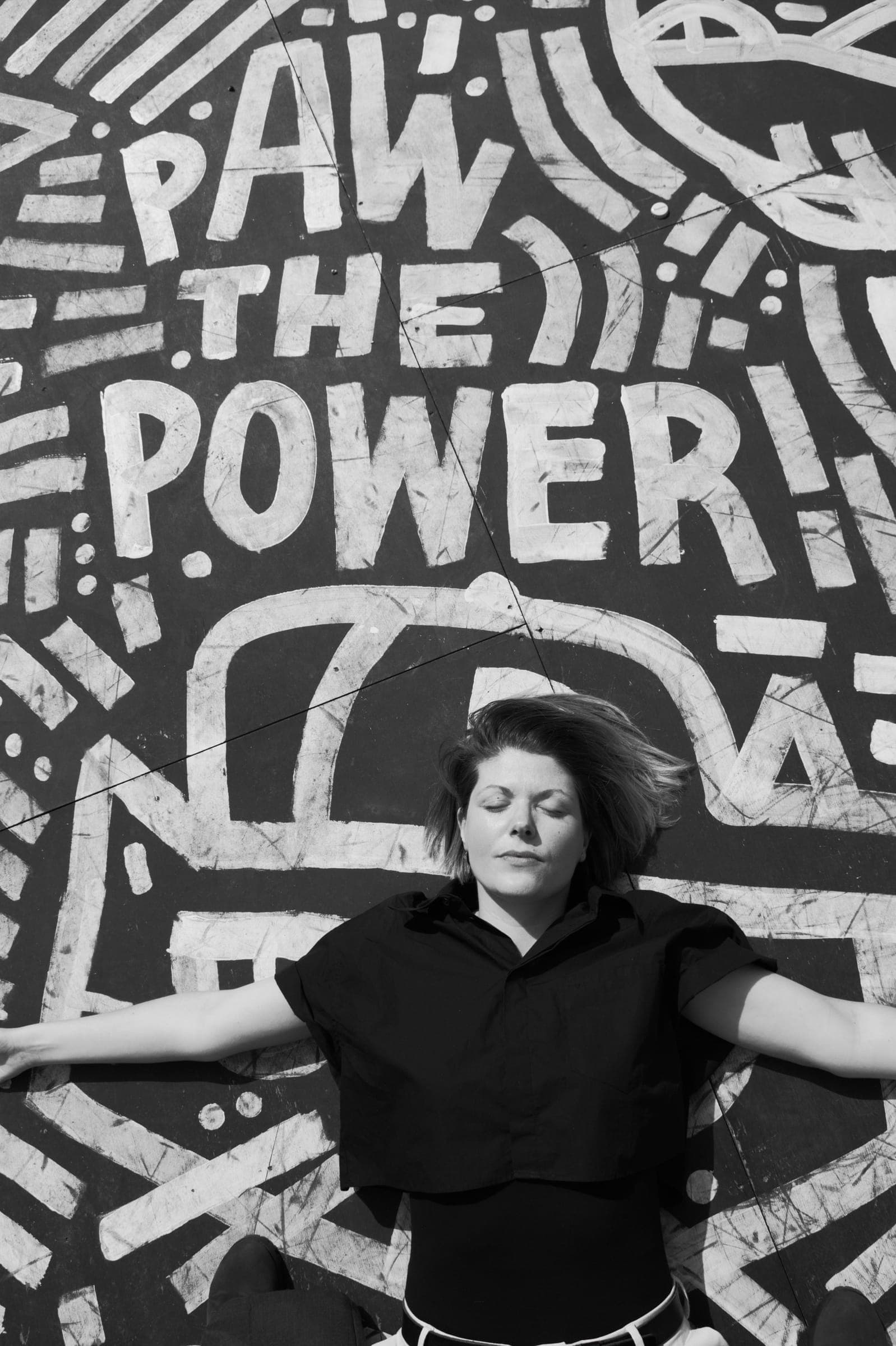 Els ligt met gespreide armen op een muurschildering met de woorden Paw the power